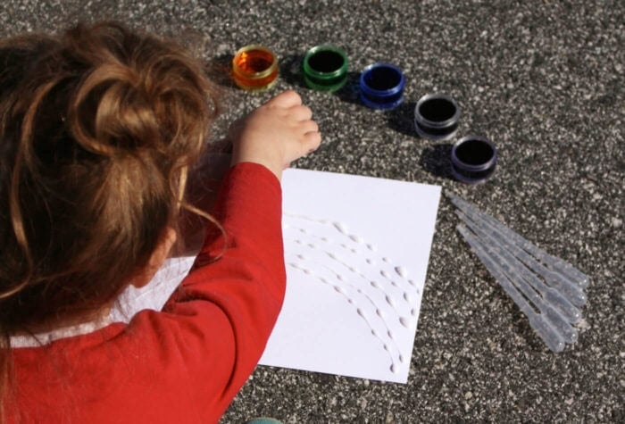 Bright Rainbow Salt Painting for Preschoolers 9 child working on rainbow salt painting art project