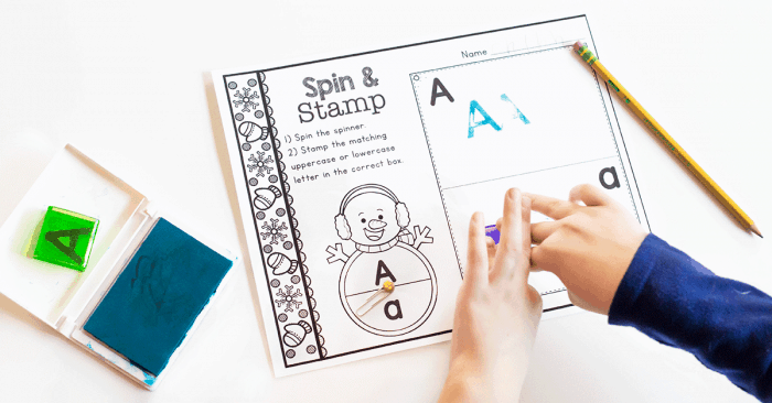 a child completing the snowman spin & stamp alphabet activity worksheet for the letter "a".