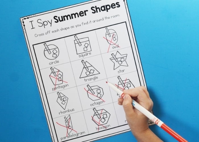 close up of a child completing the "i spy summer shapes" worksheet.