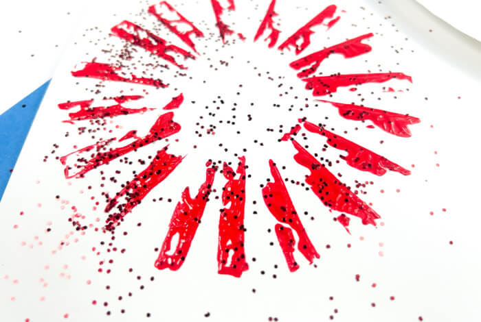 add glitter to the wet paint to make the fireworks art sparkle.