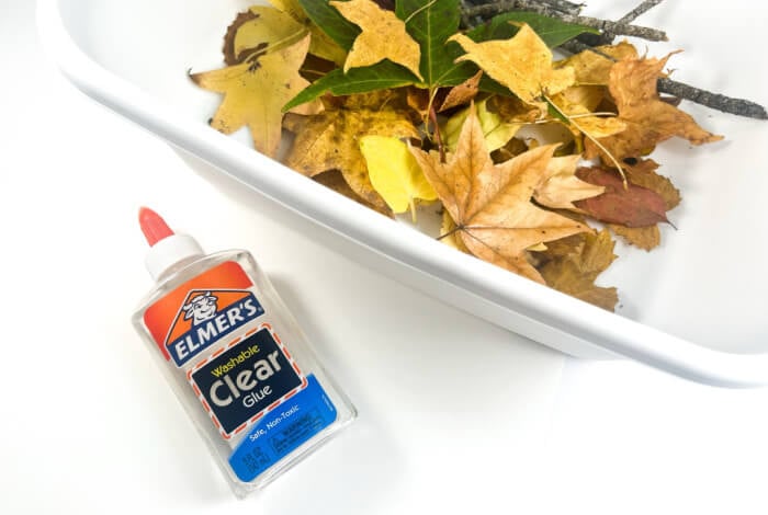 Make a Super Easy Fall Tree Craft for Preschoolers 14 clear elmer's washable school glue and a white rectangular bucket filled with fall leaves