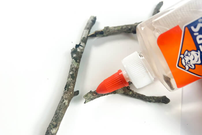 Make a Super Easy Fall Tree Craft for Preschoolers 15 gluing sticks to a white piece of paper with clear school glue to create a fall tree craft