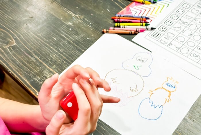 Easter Roll and Draw Art Activity for Kids 10 a child is rolling a dice and drawing a picture of a chick hatching out of an egg.