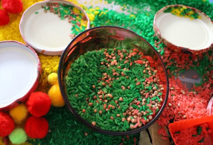 close up image of bowls and rice inside an apple sensory bin.