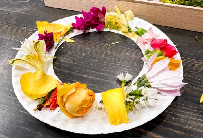 finished spring flower wreath made with a paper plate and colorful flowers.