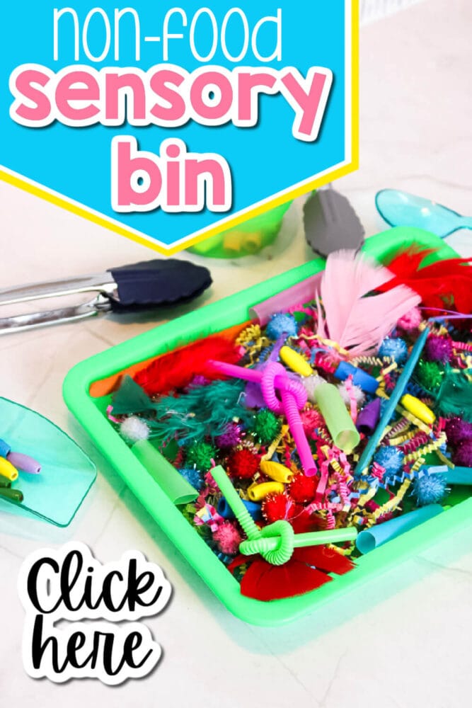 overhead photo of a colorful sensory bin made with feathers, paper shred, straws, craft sticks, and other non-food items.