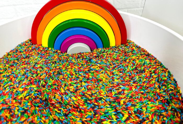 rainbow rice with a wooden rainbow stacking puzzle added to the bowl.