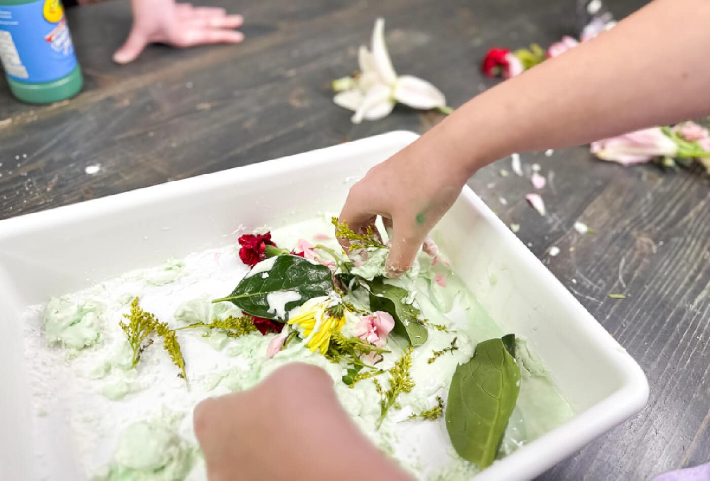 a child playing with flowers inside the spring ooblek.