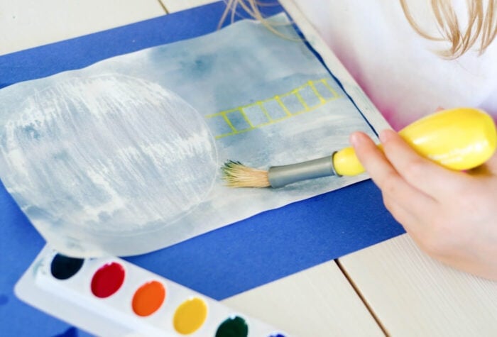 Exciting Outer Space Theme Lesson Plans for Preschool 11 a child completing a watercolor activity for the outer space lesson plans.