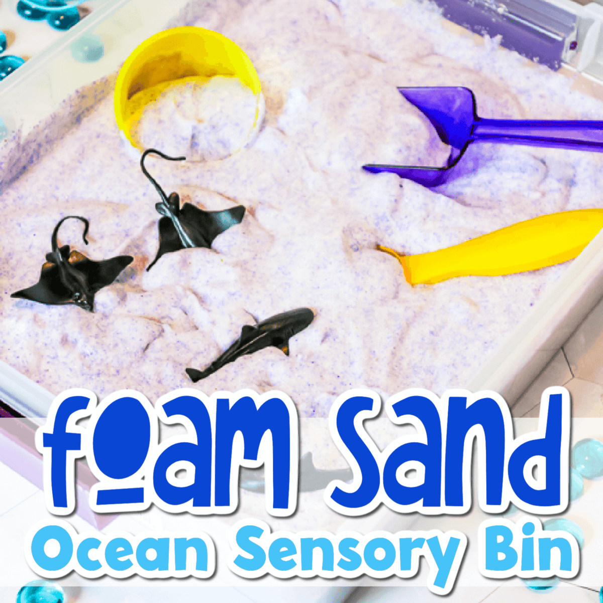 overhead image of an ocean sensory bin made with diy foam sand.