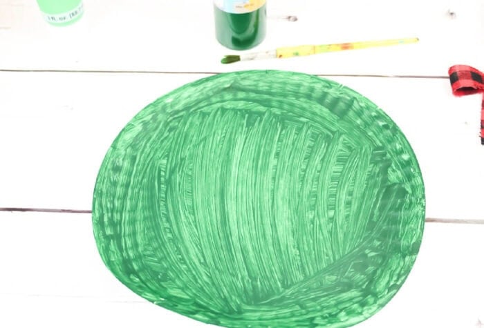 up close photo of paper plate painted green to create a paper plate christmas wreath