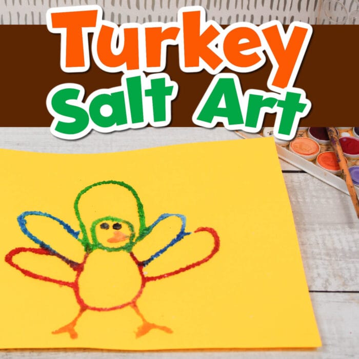 a yellow piece of construction paper with a colorful turkey salt painting on it.