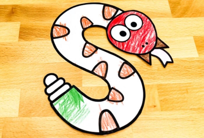 a "s is for snake" alphabet craft has been colored with red, green, and brown crayons and glued together. 