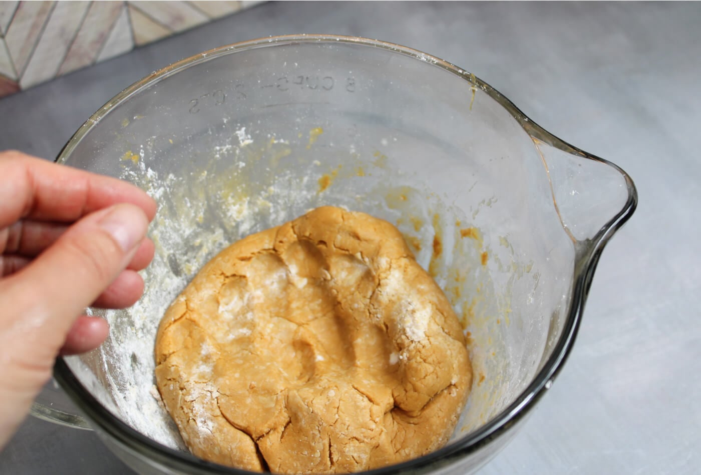 powdered sugar being mixed into wow butter and honey to create peanut-free edible play dough, showing early texture changes during this allergy-friendly recipe.