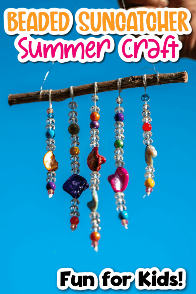 someone is holding up a handmade beaded suncatcher outside with blue sky in the background.