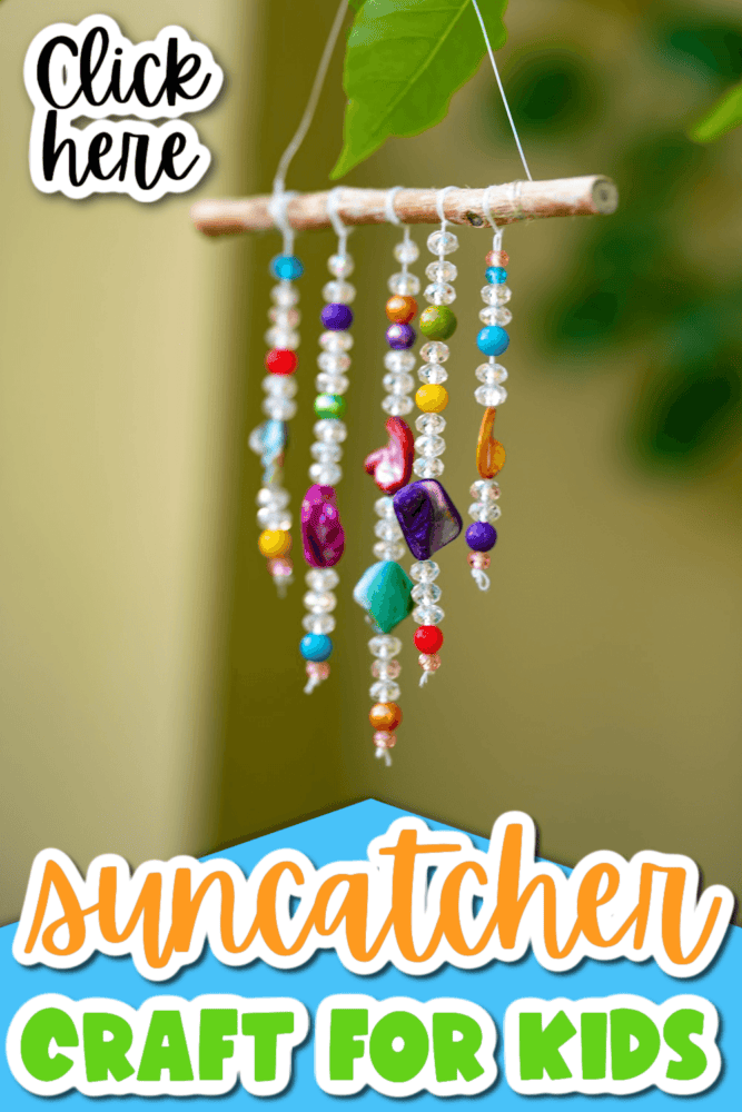 vertical image of a suncatcher craft made with beads, string, and a stick hanging from a tree branch.