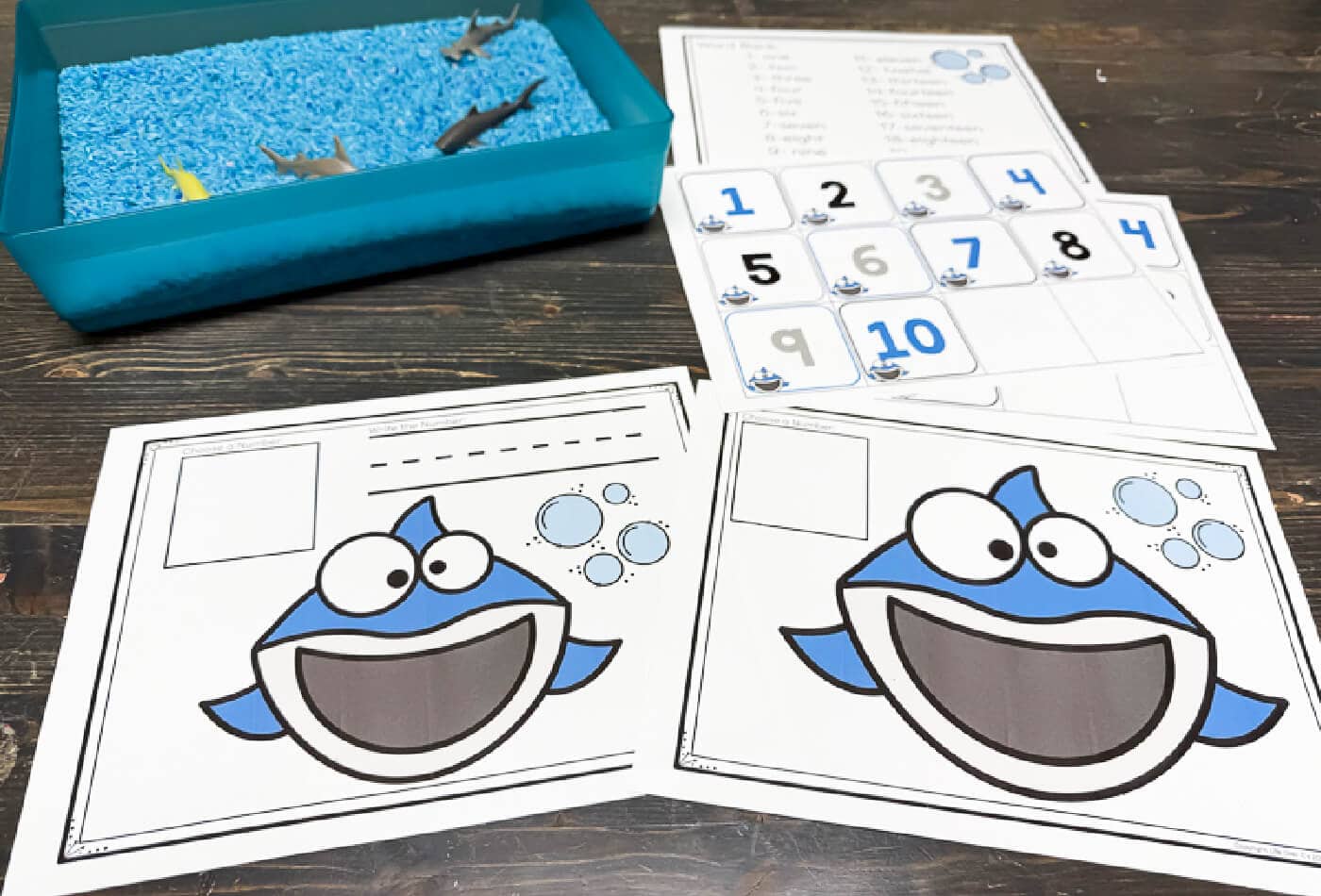 shark play dough counting mats being used by preschooler to count and match numbers with hands-on fine motor math activity