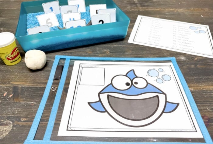 close-up of shark counting mat for preschool with play dough teeth and number card for interactive number recognition practice